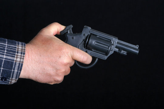 Black 9mm gun in man's hand aiming