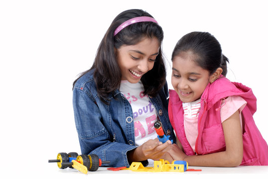 two young girls playing with mechanical blocks