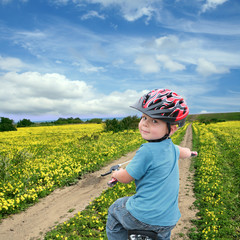 Child cycling on a spring meadow