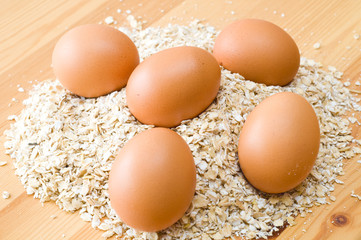 eggs and oat flakes on wooden table