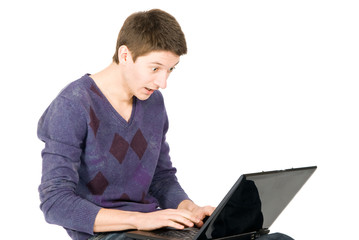 Surprised young man looks in the monitor of laptop