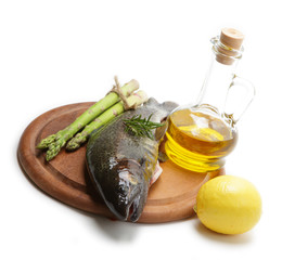 Raw trout with ingredients on a wooden board