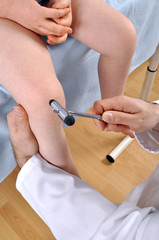 Kinderarzt mit Reflexhammer