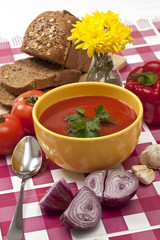 place setting with healthy homemade tomato soup, bread and veget