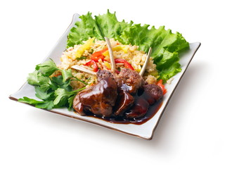 Fried meat ribs in sauce with rice salad and parsley
