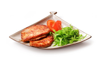 Fried meat with salad and tomato in squared plate