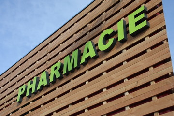 enseigne pharmacie sur un bâtiment commecial en bois