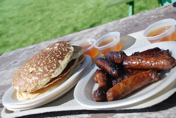 Breakfast with pancakes, sausages and maple syrup