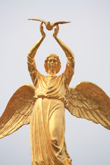 golden angel in blue sky