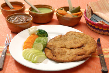 Pechuga de pollo empanizada acompañada con vegetales. México