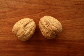 Two walnuts on a golden wood table