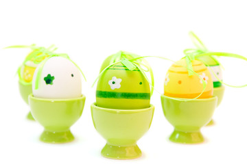 colorful easter eggs in eggcups isolated on white