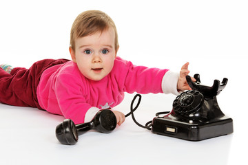 Kind spielt mit einem alten Telefon