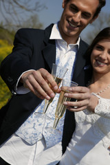 jeunes mariés trinquant avec un verre de champagne