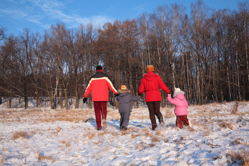 Family run from back in wood in winter