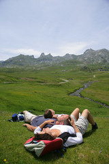 Naklejka premium famille en randonnée s'allongeant dans l'herbe