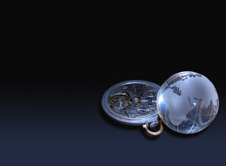 Glassy globe with old watch mechanism lying on dark