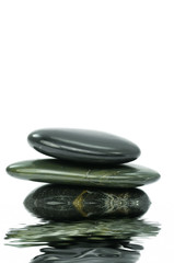 Spa stones on white background with water reflection