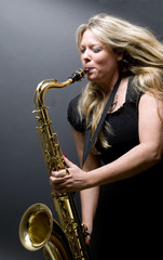 Fototapeta na wymiar sexy blond female saxophone player musician