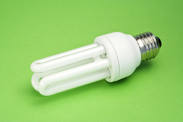 energy saving light bulb on green surface