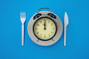 The image of an alarm clock laying in a plate.