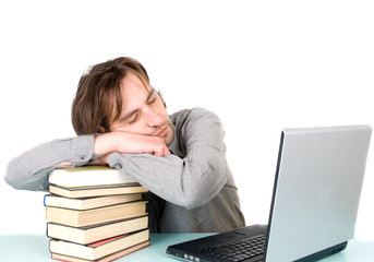 man with books and laptop sleeping