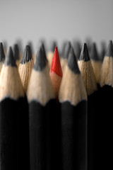 A bunch of graphite pencils with one red in the middle