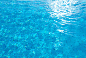 blue background with sun reflected in the swimming-pool water