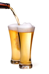 Beer being pour on a glass over a white background