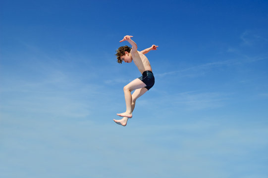 Boy jumping against ble sky