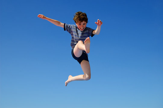 Boy jumping against ble sky