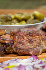Grilled or barbecued pork meat with onion and pickles