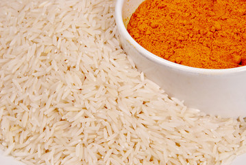 Close up of raw rice and curry powder in a bowl.