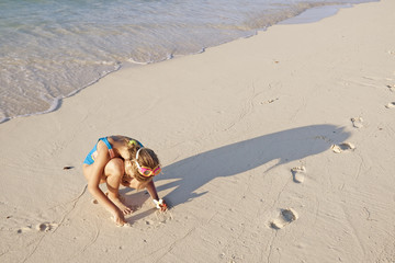 Kidl playing on the ocean beach