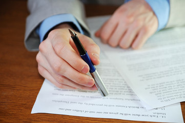 A businessman signs papers.