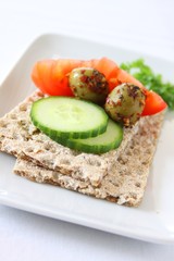 knäckebrot mit tomaten, gurken und oliven belegt