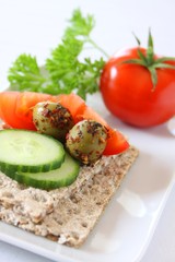 knäckebrot mit tomaten, gurken und oliven belegt