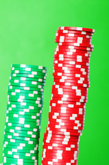 Stack of red and green casino chips against green background