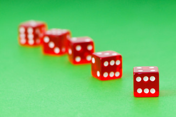 Red dice against green background - shallow DOF
