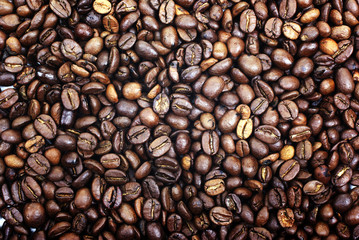 Heap of brown roasted coffee beans as background or backdrop.