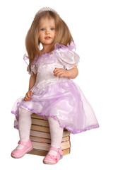 Baby girl sitting on book.