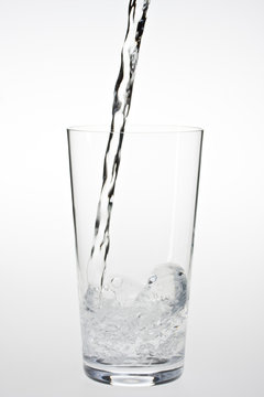 Wasser spritzt in ein Trinkglas