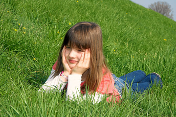 Mädchen liegt im Gras