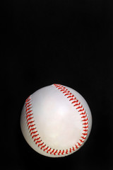 Baseball on black background ready for type.