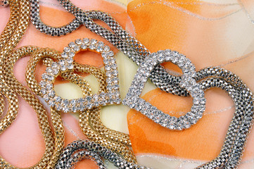 Jewelry with heart on background silk fabrics