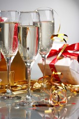 Glasses of champagne, gifts with red tapes and bows