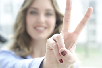junge frau macht victory zeichen mit fingern und lacht