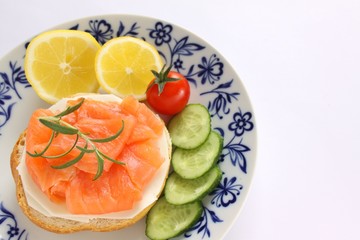 belegtes brötchen mit lachs und käse, gurke, tomate und zitrone