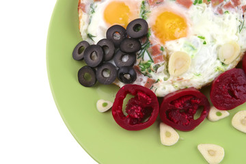 eggs fried with red eggplants and black olives on green dish