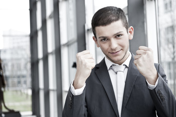 junger geschäftsmann hebt fäuste